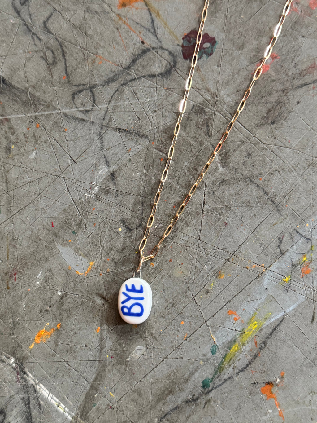 White Porcelain OK Bye Pendant Necklace in 18" Gold Paperclip Chain
